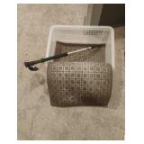 Plastic basket, walking stick and a floor mat