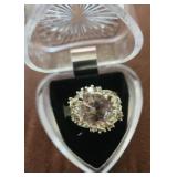 Ring is a pink cubic zirconia halo ring set in