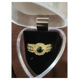 This is a gold-plated ring with a central green