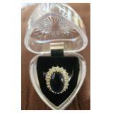 Large blue stone surrounded by faux diamonds.