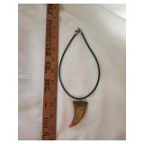 Tribal tooth pendant on black leather cord.