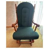 Wooden glider rocker with green cushions
