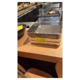 Three stainless steel baking pans with lids