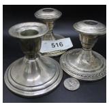 Three sterling candlesticks
