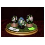 Three cloisonne eggs on stand