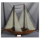 Wood carved sailboat with feathered sails