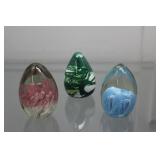 Three egg shaped paperweights