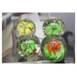 Four timed release floral paperweights