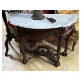Marble top entry table with botanical carved skirt
