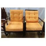 Two porch rocking chairs with orange cushions