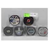 Six NHL Hockey Pucks in cases some with signatures