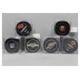 Six NHL Hockey Pucks in cases some with signatures