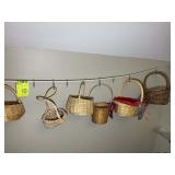 GROUP OF SMALL WICKER BASKETS HANGING ON WALL