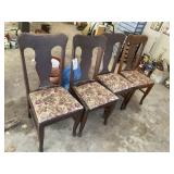 Group of three wooden dining chairs, some with dam