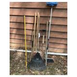 Group of yard tools, post hole digger rake shovel