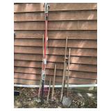 Group of yard tools, pole lopper, metal rakes pick