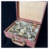 Old travel case filled with antique silverware