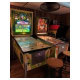 Group of vintage pinball machines and arcade games arranged in a private game room setting.