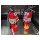 TWO RED FIRE EXTINGUISHERS