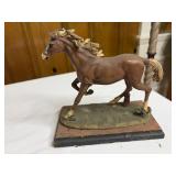 Old galloping horse statue on base