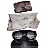 Three pairs wire-rim eyeglasses with metal cases
