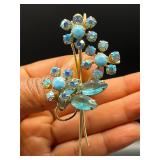 vintage floral brooch features blue rhinestones