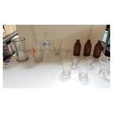 Assorted Drinkware And Brown Glass Bottles