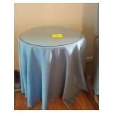 2 round tables with tablecloth and glass tops