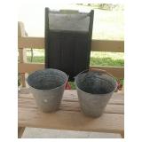 Washboard with two buckets. Buckets have holes on