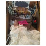 Porcelain doll with Christmas village house