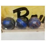 3 bowling balls with wooden rack