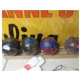 4 bowling balls with wooden rack