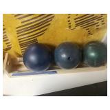 3 bowling balls with wooden rack