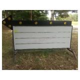 Giant arrow sign with letters, lights and yellow