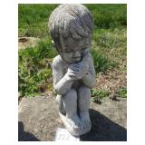 Concrete boy and bird statue