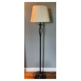 Black metal floor lamp with a white shade. Powers