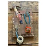 Brown leather tool belt with a few tools.