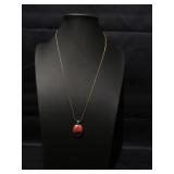 Gold tone chain with red and black pendent