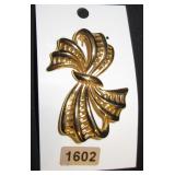 a bow brooch in gold tone