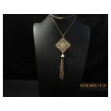 Goldtone filgree pendent with a tassel