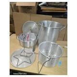 A lot of aluminum cooking pots with accessories.