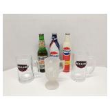 Group of full soda bottles  and glass mugs