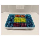 Group of decorative glass beads in storage bin