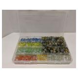 Group of decorative glass beads in storage bin
