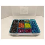 Group of decorative glass beads in storage bin