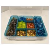Group of decorative glass beads in storage bin