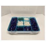 Group of decorative glass beads in storage bin