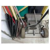 GARDEN TOOLS UNDERNEATH STEPS INCLUDING RAKES AND GARDEN TRACTOR FERTILIZER SPREADER