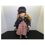 Porcelain Doll with Red Plaid Dress and Black Cardigan