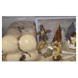 Ivory or Cream-Colored Pillar Candles Alongside Various Gold and Silver Christmas Decorations, Including a Decorative Sign, Ornaments, and a Small Snowman